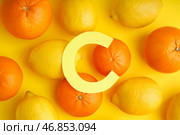 Композиция с бумажной буквой C, свежими лимонами и апельсинами на желтом фоне. Стоковое фото, фотограф Pixel_shot / Фотобанк Лори
