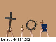 Женские руки с венцом из терновника, деревянные кресты и Священная Библия на цветном фоне. Концепция Страстной Пятницы. Стоковое фото, фотограф Pixel_shot / Фотобанк Лори