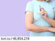 Женщина с глюкозным датчиком для измерения уровня сахара в крови и ланцетным пером на лиловом фоне. Концепция диабета. Стоковое фото, фотограф Pixel_shot / Фотобанк Лори