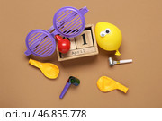 Календарь с забавными очками, воздушными шариками и праздничными свистками на коричневом фоне. День смеха и шуток. Стоковое фото, фотограф Pixel_shot / Фотобанк Лори