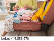 Женский турист упаковывает летнюю одежду в чемодане дома, крупным планом. Стоковое фото, фотограф Pixel_shot / Фотобанк Лори