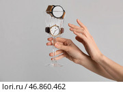 Женщина со стеклом и стильными наручными часами на сером фоне. Стоковое фото, фотограф Pixel_shot / Фотобанк Лори