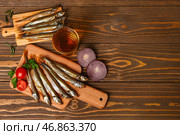 Доски с вкусной копченой мойвой и бокалом пива на деревянном фоне. Стоковое фото, фотограф Pixel_shot / Фотобанк Лори