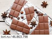 Фольга с вкусным шоколадом, кофейными зернами и анисовыми звездочками на светлом деревянном фоне, крупным планом. Стоковое фото, фотограф Pixel_shot / Фотобанк Лори