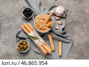 Миски с хумусом, оливками и кучей вкусных итальянских гриссини на фоне гранж. Стоковое фото, фотограф Pixel_shot / Фотобанк Лори