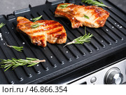 Современный электрический гриль с вкусными стейками на темном фоне. Стоковое фото, фотограф Pixel_shot / Фотобанк Лори