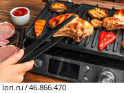 Женщина готовит вкусные стейки и овощи на современном электрическом гриле за столом, крупным планом. Стоковое фото, фотограф Pixel_shot / Фотобанк Лори
