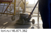 Builder polishing mortar floor at construction site of new appartments. Стоковое фото, фотограф David Kashakhi / Фотобанк Лори