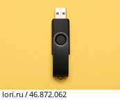 Черный USB-накопитель на желтом фоне. Стоковое фото, фотограф Pixel_shot / Фотобанк Лори