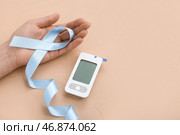 Женщина с лентой осведомленности и глюкометром на бежевом фоне. Концепция диабета. Стоковое фото, фотограф Pixel_shot / Фотобанк Лори