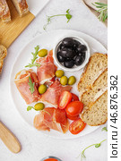 Тарелка с ломтиками вкусного хамона и хлеба на светлом фоне. Стоковое фото, фотограф Pixel_shot / Фотобанк Лори