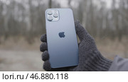 Moscow, Russia - 11.28.2020: man hand holding Iphone demonstrating its back side. Редакционное фото, фотограф David Kashakhi / Фотобанк Лори