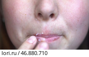 Close up of woman fingers applying ointment onto lips, treatment of herpes infection and virus. Стоковое фото, фотограф David Kashakhi / Фотобанк Лори