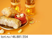 Тарелка с вкусной пахлавой на оранжевом фоне, крупным планом. Стоковое фото, фотограф Pixel_shot / Фотобанк Лори