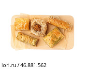 Деревянная доска с вкусной пахлавой на белом фоне. Стоковое фото, фотограф Pixel_shot / Фотобанк Лори
