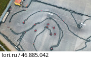 Aerial view of the karts pilots traning or competing on the karting trace in protective uniform and helmet. Стоковое фото, фотограф David Kashakhi / Фотобанк Лори
