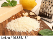 Доска с вкусным тертым сыром пармезан на светлом деревянном фоне, крупным планом. Стоковое фото, фотограф Pixel_shot / Фотобанк Лори