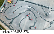 Aerial view of the karts pilots traning or competing on the karting trace in protective uniform and helmet. Стоковое фото, фотограф David Kashakhi / Фотобанк Лори