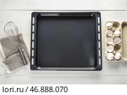 Противень с яйцами, венчиком и салфеткой на белом деревянном фоне. Стоковое фото, фотограф Pixel_shot / Фотобанк Лори