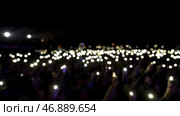 Audience holding phones with shining flashlights during the concert, romantic atmosphere. Стоковое фото, фотограф David Kashakhi / Фотобанк Лори