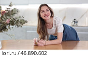 Pleased joyful housewife with cup of coffee or cocoa in modern kitchen. Стоковое видео, видеограф Яков Филимонов / Фотобанк Лори