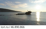 Old sunk boat near sea shore on big mountain and blue sky background. Стоковое фото, фотограф David Kashakhi / Фотобанк Лори