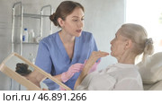 Old woman patient lying on clinical chair discussing face aesthetic procedures with doctor. Стоковое видео, видеограф Яков Филимонов / Фотобанк Лори