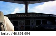 Small twin turbo engine airplane cockpit view while in flight with gauges lit up and fluffy white and blue clouds in the window. Стоковое фото, фотограф David Kashakhi / Фотобанк Лори