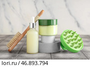 Подиумы из гипса с силиконовой массажной щеткой для головы и косметическими продуктами на сером кафельном столе на фоне белого грунтового фона. Стоковое фото, фотограф Pixel_shot / Фотобанк Лори