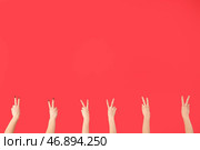 Женские руки, показывающие жест мира на красном фоне. Стоковое фото, фотограф Pixel_shot / Фотобанк Лори