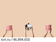 Руки, держащие ведра с попкорном и очки виртуальной реальности на бежевом фоне. Стоковое фото, фотограф Pixel_shot / Фотобанк Лори