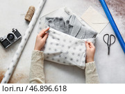 Женщина заворачивает перчатки и свитер на столе. Стоковое фото, фотограф Pixel_shot / Фотобанк Лори