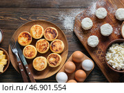 Тарелка с вкусными сырниками и ингредиентами на деревянном фоне. Стоковое фото, фотограф Pixel_shot / Фотобанк Лори