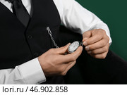 Модный джентльмен проверяет свои старинные часы на цветном фоне, крупным планом. Стоковое фото, фотограф Pixel_shot / Фотобанк Лори
