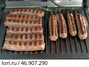 Приготовление чевапчичи (колбасок) на электрическом гриле - Cooking chevapchichi (sausage) on an electric grill. Стоковое фото, фотограф Владислав Дельдюгинов / Фотобанк Лори