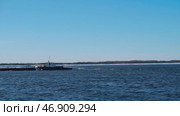 Huge ships with cargo move through the snowy sea, behind which the forest is visible. Стоковое фото, фотограф David Kashakhi / Фотобанк Лори