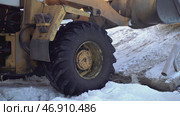In the snow, a bulldozer spins its wheels when it pulls something heavy. Стоковое фото, фотограф David Kashakhi / Фотобанк Лори