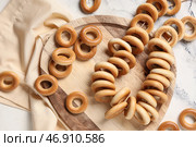 Деревянная доска с веревкой из вкусных бубликов на мраморном фоне. Стоковое фото, фотограф Pixel_shot / Фотобанк Лори