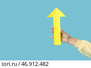 Женская рука с бумажной стрелкой, указывающей на что-то на синем фоне. Стоковое фото, фотограф Pixel_shot / Фотобанк Лори