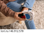 Молодой человек надевает ортопедическую стельку на стопу у себя дома, крупный план. Стоковое фото, фотограф Pixel_shot / Фотобанк Лори