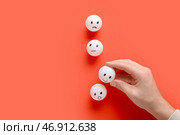 Мужская рука и смайлы для оценки на красном фоне. Концепция опроса. Стоковое фото, фотограф Pixel_shot / Фотобанк Лори