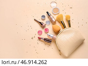 Композиция с косметичкой, баночками с блестками, пайетками, косметическими продуктами и аксессуарами на бежевом фоне. Стоковое фото, фотограф Pixel_shot / Фотобанк Лори