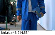 A man in a blue suit and a white helmet is trying to open special electrical equipment for work. Стоковое фото, фотограф David Kashakhi / Фотобанк Лори