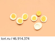 Ломтики вкусных отваренных яиц на оранжевом фоне. Стоковое фото, фотограф Pixel_shot / Фотобанк Лори