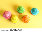 Вкусные красочные капкейки на желтом фоне. Стоковое фото, фотограф Pixel_shot / Фотобанк Лори