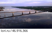 Aerial view of a long bridge above the wide river in sunset. Стоковое фото, фотограф David Kashakhi / Фотобанк Лори