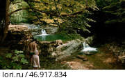 Creative.People in swimsuits walking on the lake in the mountains and green thickets of trees are visible. Стоковое фото, фотограф David Kashakhi / Фотобанк Лори