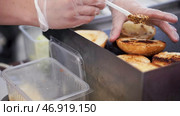 Baking potatoes on the grill, the cook lubricates the potatoes with sauce. Стоковое фото, фотограф David Kashakhi / Фотобанк Лори