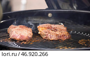 Beef steaks on the grill with flames. Стоковое фото, фотограф David Kashakhi / Фотобанк Лори