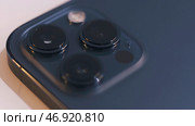 Close up of three cameras of a beautiful blue smartphone isolated on white background. Редакционное фото, фотограф David Kashakhi / Фотобанк Лори